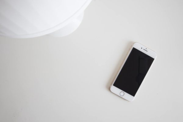 Top down view of an Iphone on a white desk