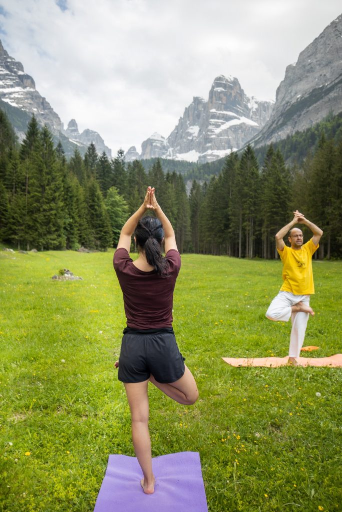 Yoga teacher and student on tree pose variation