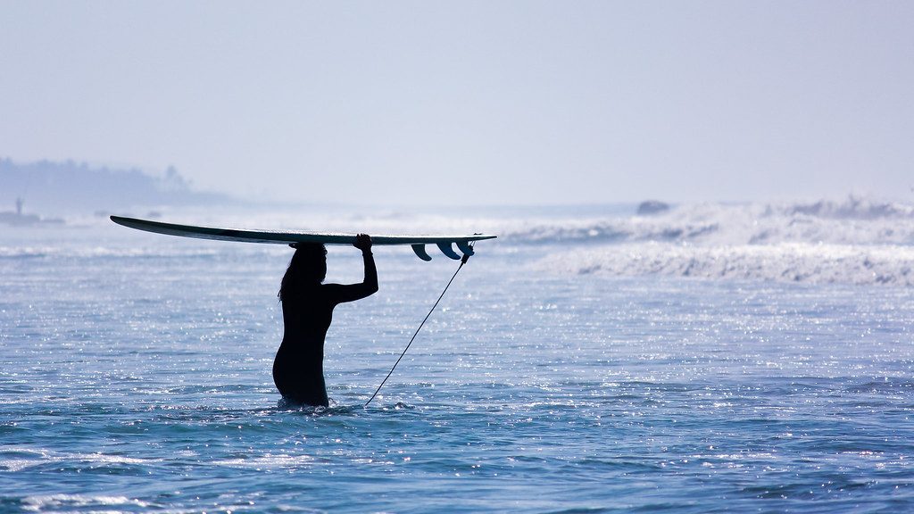 Female surfer heading out to a wave in Hossegor, France